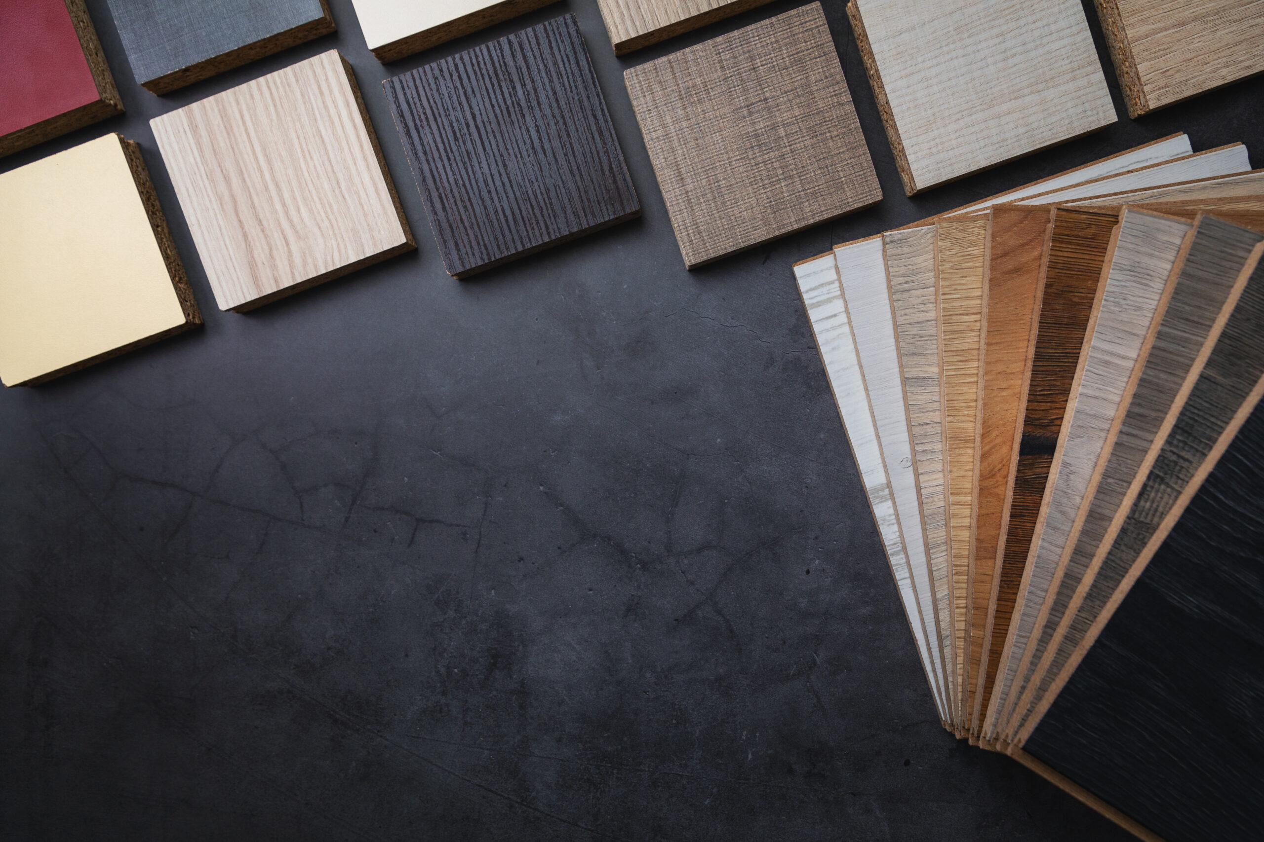 wood texture laminate furniture and flooring material samples on dark stone background with copy space